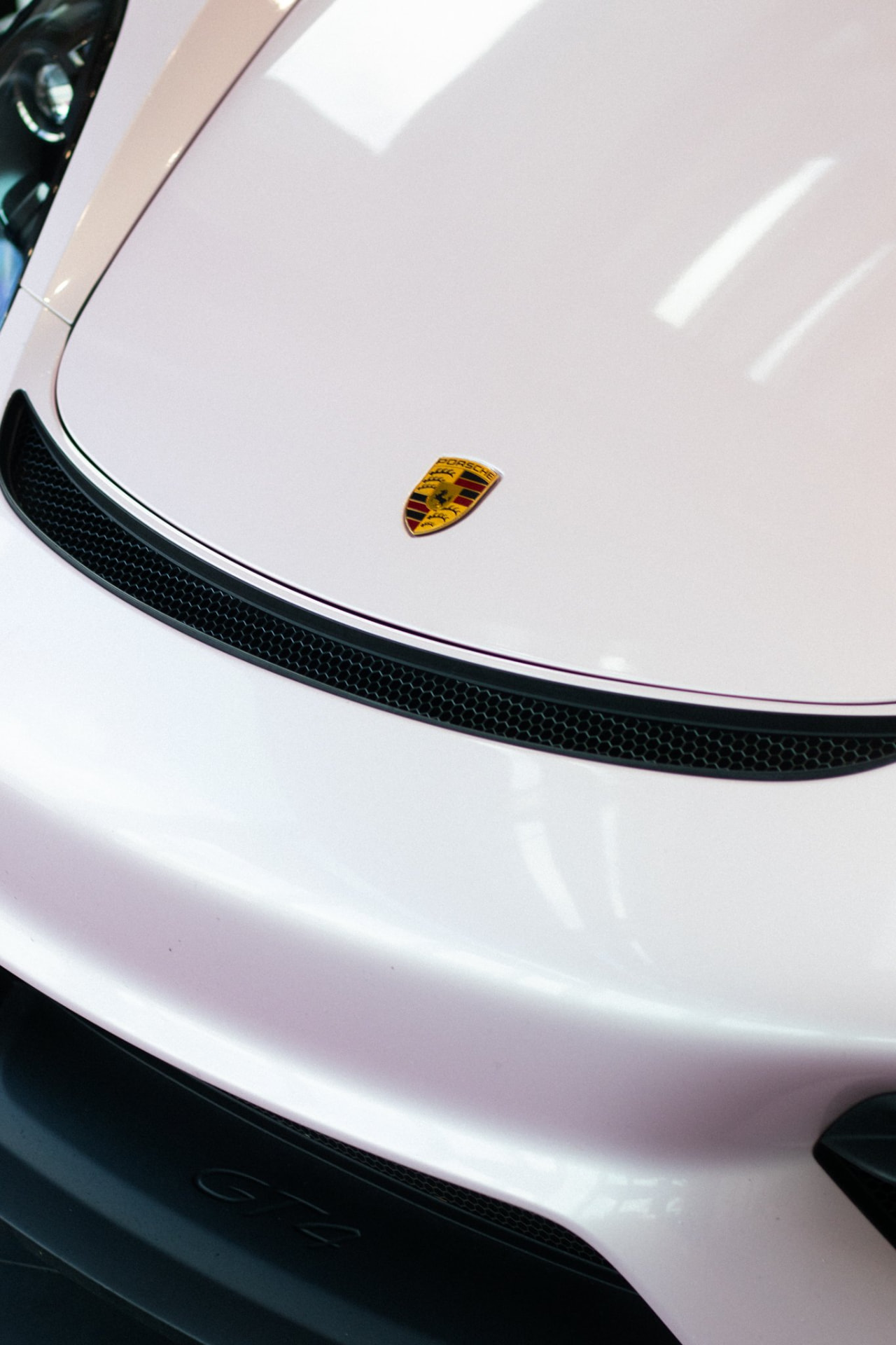 Porsche crest detail on a white hood